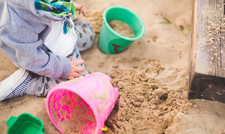 little baby playing in sand image